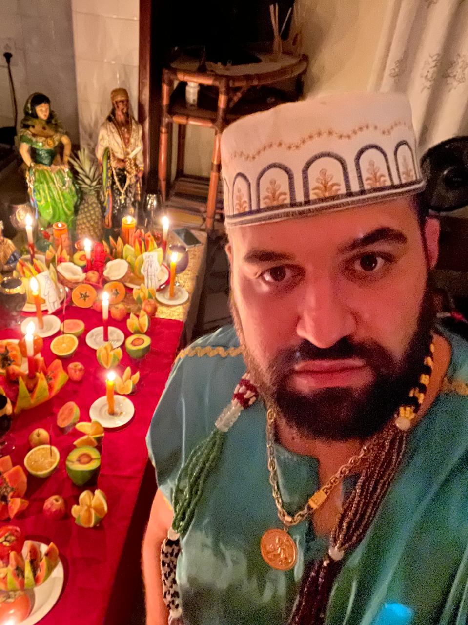 Pai Sebastian em ritual no altar com frutas e velas